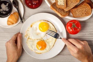 Erkek masa w kızarmış yumurta ve çatal ile plaka tutan eller