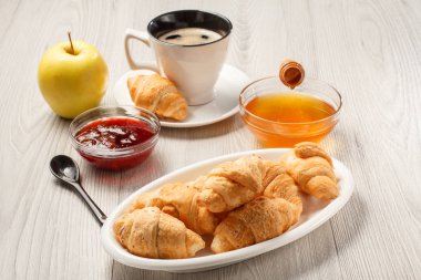 Beyaz porselen tabak, çilek reçel kase üzerinde taze kruvasanlar