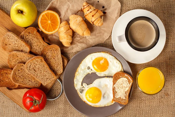 Tallrik med stekt ägg, glas apelsinjuice, kopp svart kaffe — Stockfoto