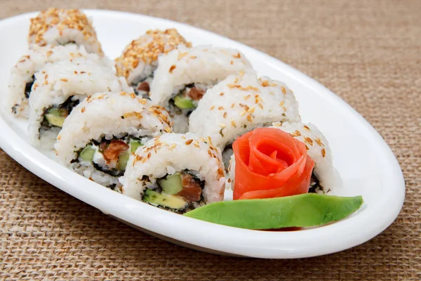 Uramaki rotoli di sushi con pesce rosso e zenzero sottaceto e pezzo di o — Foto Stock