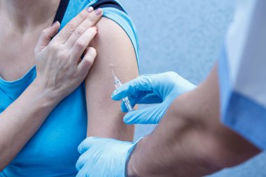 Bir aşı için üst kol için şırınga tutarak doktor eller 