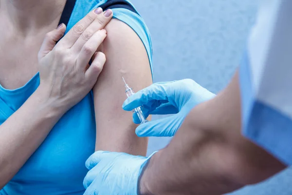 Bir aşı için üst kol için şırınga tutarak doktor eller 
