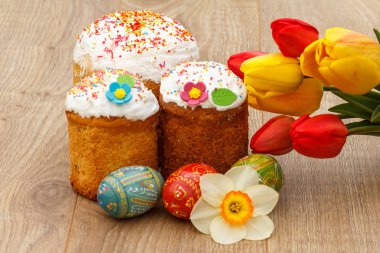Tatlı Paskalya kek, boyalı Paskalya yumurtaları, kırmızı ve Sarı Lale, 