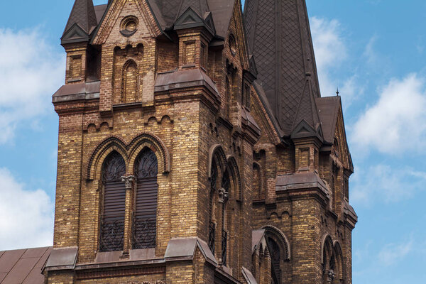 Tower fragment of roman catholic church with blue sky and white 