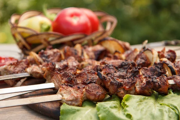 Gegrild varkensvlees op een spies gebakken op de grill en sla bladeren — Stockfoto