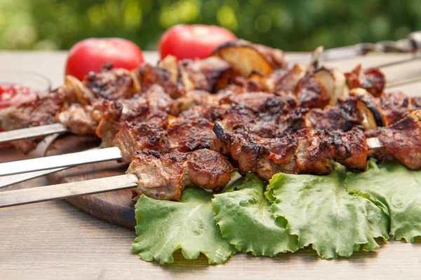 Carne di maiale alla griglia su spiedini arrosto alla griglia e foglie di lattuga — Foto Stock