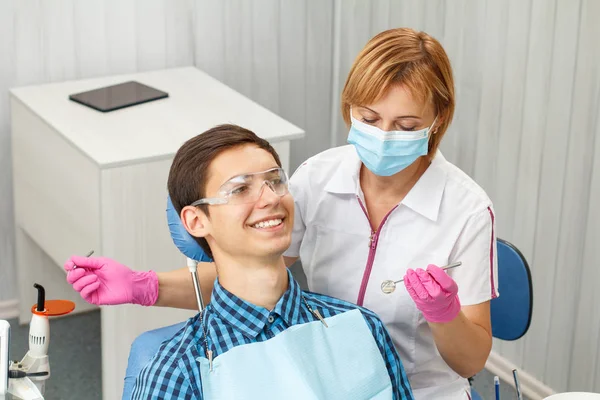 Dentysta kobieta i młody mężczyzna w gabinecie stomatologicznym — Zdjęcie stockowe