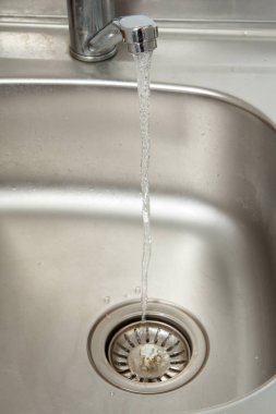 Su akışı bir açık krom musluk akar
