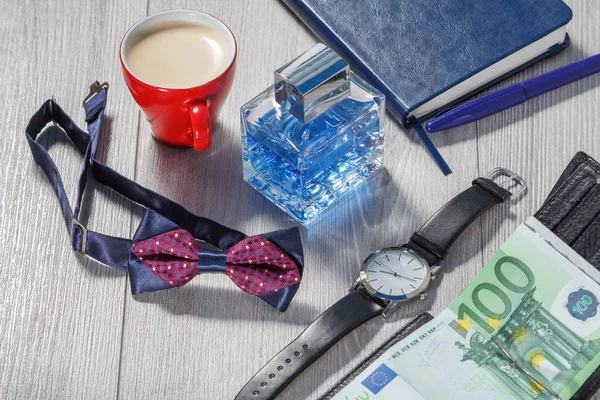 Man perfume, watch with a black leather strap, bow tie, notebook