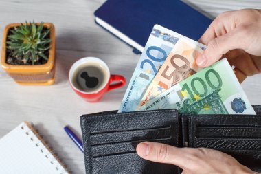 Erkek siyah deri cüzdan euro ürün reçetelerinin tam gr üzerinde tutan eller