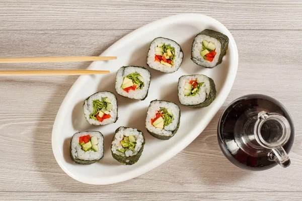 Rotoli di sushi con riso, pezzi di avocado, cetriolo, campanello rosso — Foto Stock