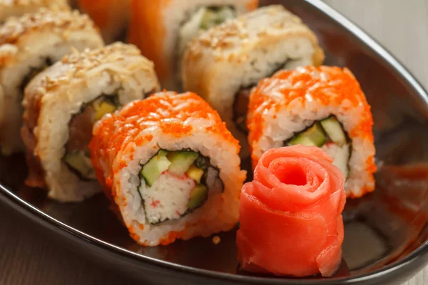 Zenzero messo sotto aceto da vicino nella forma di rosa rossa e rotoli di sushi — Foto Stock