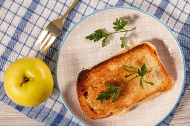 Tereyağı ve peynir beyaz tabak, apple ve çatal n ile tost