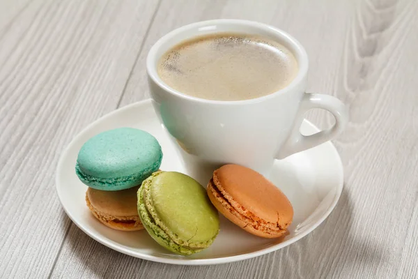 Tasse de café, délicieux gâteaux de macarons de différentes couleurs sur wh — Photo