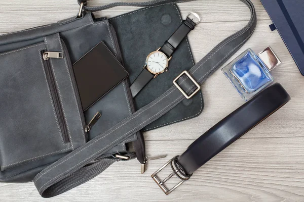 Kožená taška přes rameno pro muže s mobilním telefonem a náramkové hodinky na — Stock fotografie