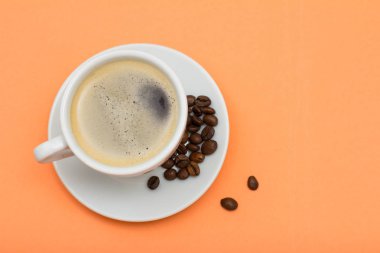 Fincan kahve ve kahve çekirdekleri şeftali arka plan üzerinde