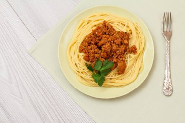 Metal çatal ile bir tabak üzerinde spagetti bolonez.