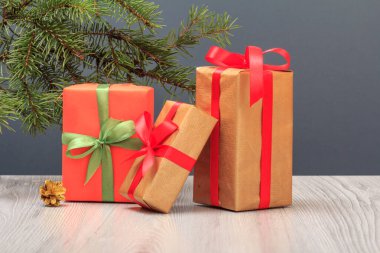 Gri arkaplanda hediye kutuları ve köknar ağacı dalı