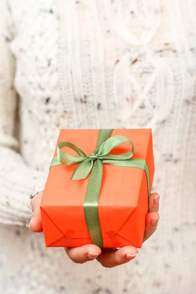 Mujer sosteniendo una caja de regalo atada con cinta verde en la mano . — Foto de Stock
