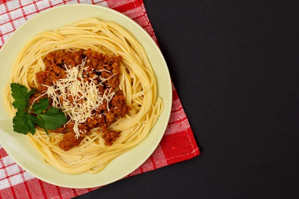 Espaguetis boloñesa en un plato con servilleta de cocina . —  Fotos de Stock