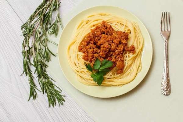 Espaguetis con salsa boloñesa en un plato con tenedor de metal . —  Fotos de Stock