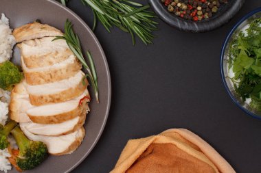 Fırında tavuk göğüsleri veya tepside pirinç ve sebze ile plaka üzerinde fileto.