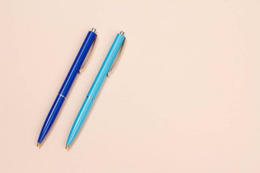 Bej arka planda iki plastik kalem..