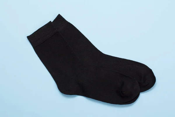 Пара черных шерстяных мужских носков на синем фоне . — стоковое фото