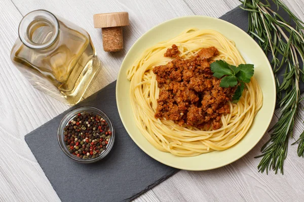 Espaguetis boloñeses en un plato con botella de vino . —  Fotos de Stock