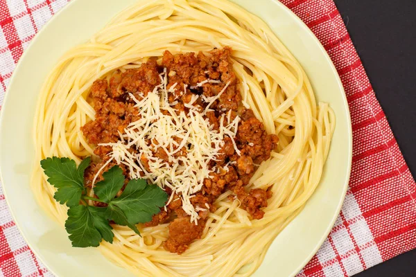 Espaguetis boloñesa en un plato con servilleta de cocina . —  Fotos de Stock