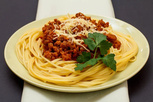 Espaguetis boloñesa en un plato con servilleta de cocina . —  Fotos de Stock