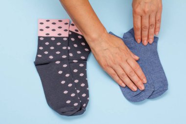 Mavi arka planda kadın çorapları olan kadın elleri..