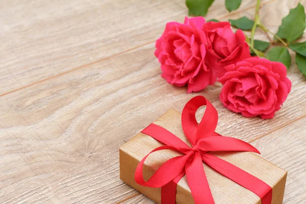 Geschenk doos met rozen bloemen op de achtergrond. — Stockfoto