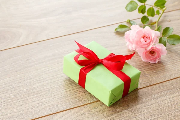 Cadeaudoosje op houten planken met rozenbloemen — Stockfoto