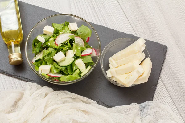 Свежий овощной салат с сыром, огурцом и редиской на каменной доске . — стоковое фото