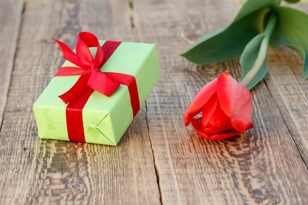 Подарункова коробка з квіткою тюльпанів на дерев'яному фоні . — стокове фото