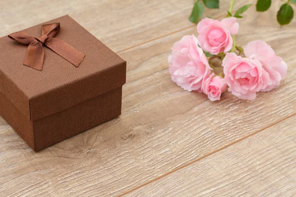 Подарочная коробка с цветами роз на заднем плане . — стоковое фото