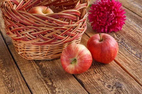 Just picked apples in a wicker basket on old wooden boards — Stock Photo, Image