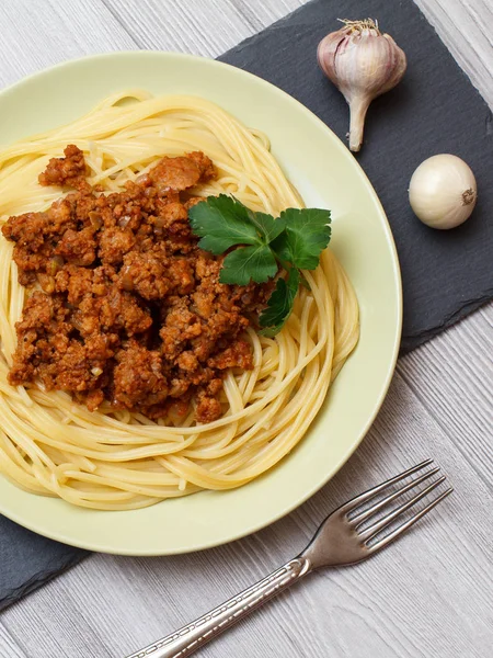 Espaguetis boloñeses en un plato con tenedor . —  Fotos de Stock