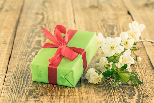 Geschenk doos met bloemen op de houten achtergrond. — Stockfoto