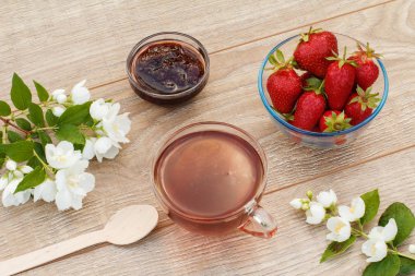 Bir bardak çay, beyaz yasemin çiçekli çilek.