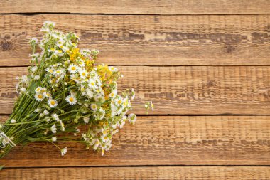 Eski tahta üzerinde bir buket kır çiçeği.