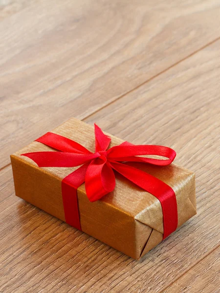 Подарочная коробка в крафтовой бумаге на деревянном столе . — стоковое фото