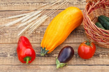 Sebzeler ve eski tahtalarda hasır bir sepet..