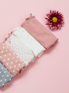 Pembe arka planda çiçek tomurcukları olan güzel kadın pamuğu külotu..