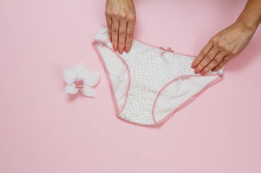 Pembe arka planda güzel külotlu kadın elleri..