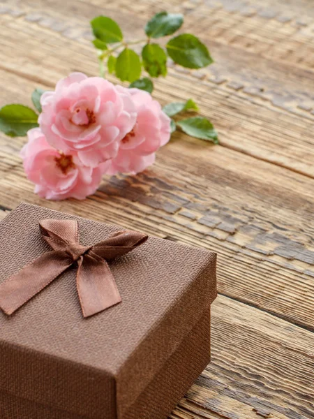 Caixa de presente em tábuas de madeira com flores de rosa — Fotografia de Stock