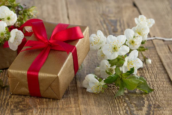 Caja de regalo con flores en el fondo de madera . — Foto de Stock