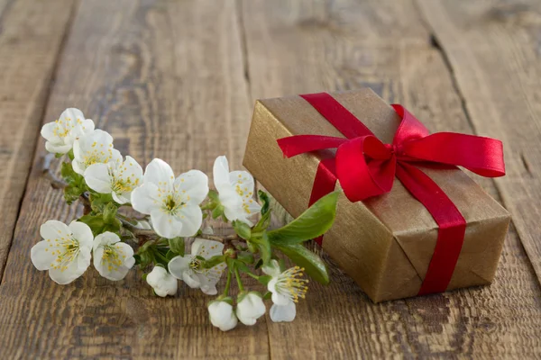 Dárková krabice s květinami na dřevěném pozadí. — Stock fotografie