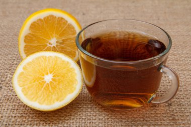 Bir fincan çay ve arka planda bir parça limon.